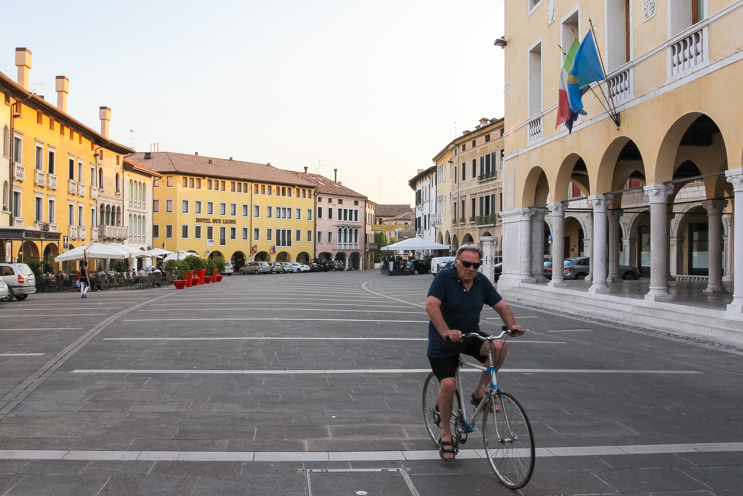 Mit dem Rennrad über die leere Piazza, im Hintergrund das Hotel Due Leoni
